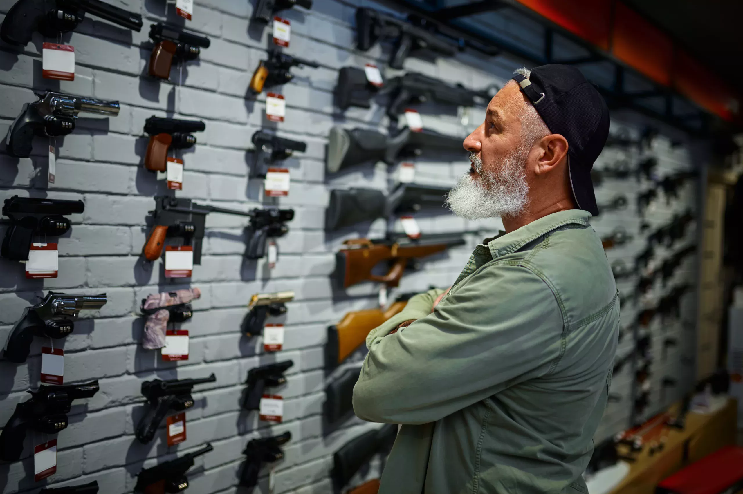 Man-looking-at-firearms-scaled (1) - Moneybox Moneybox is the #1 Payment Solution provider for Firearms Friendly Credit Card Processing